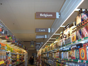 Craft beer aisles in a grocery store. Each aisle is labeled with the name of a different country.