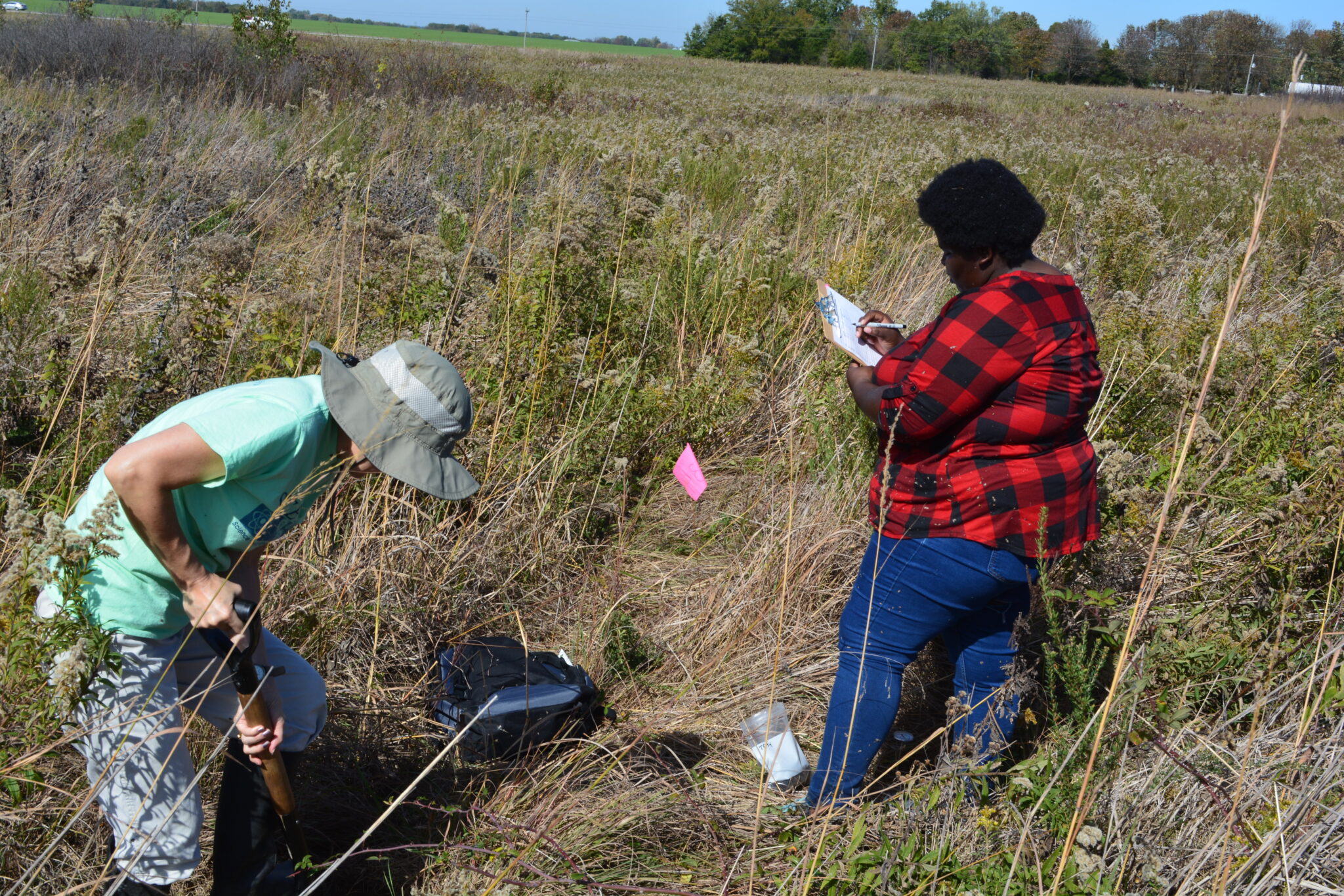 Volunteers digging into the soil in a field as part of the MO Dirt program.
