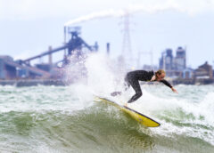 Surfers: A surfer rides a wave against the industrial backdrop of Lake Michigan. (Credit: Mike Killion/Courtesy of Surfrider)