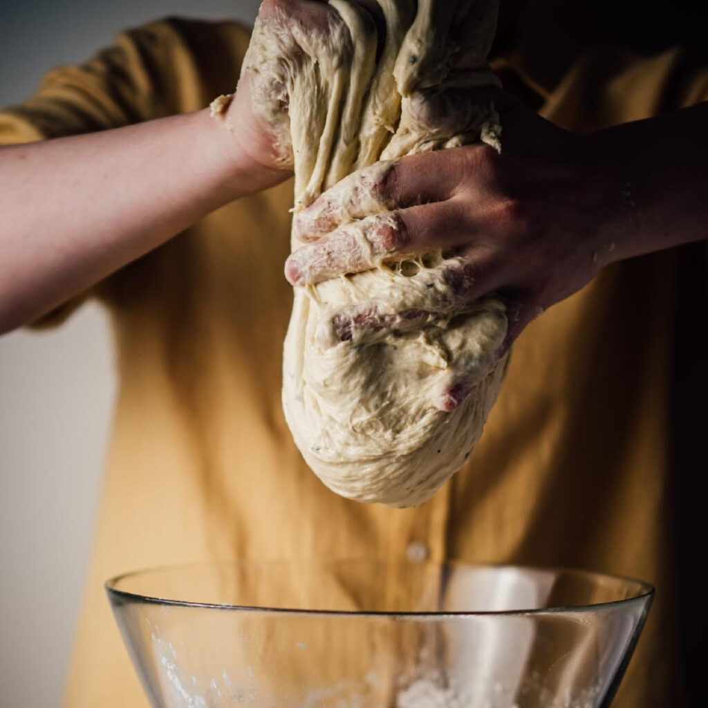 Person manipulating sourdough bread dough
