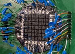 Prototype of sound sensor, which is an electrical board resembling a black square and wires attached to nodes on all four sides