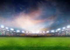 a football field flooded with bright lights and a blurry swirl of white light in center