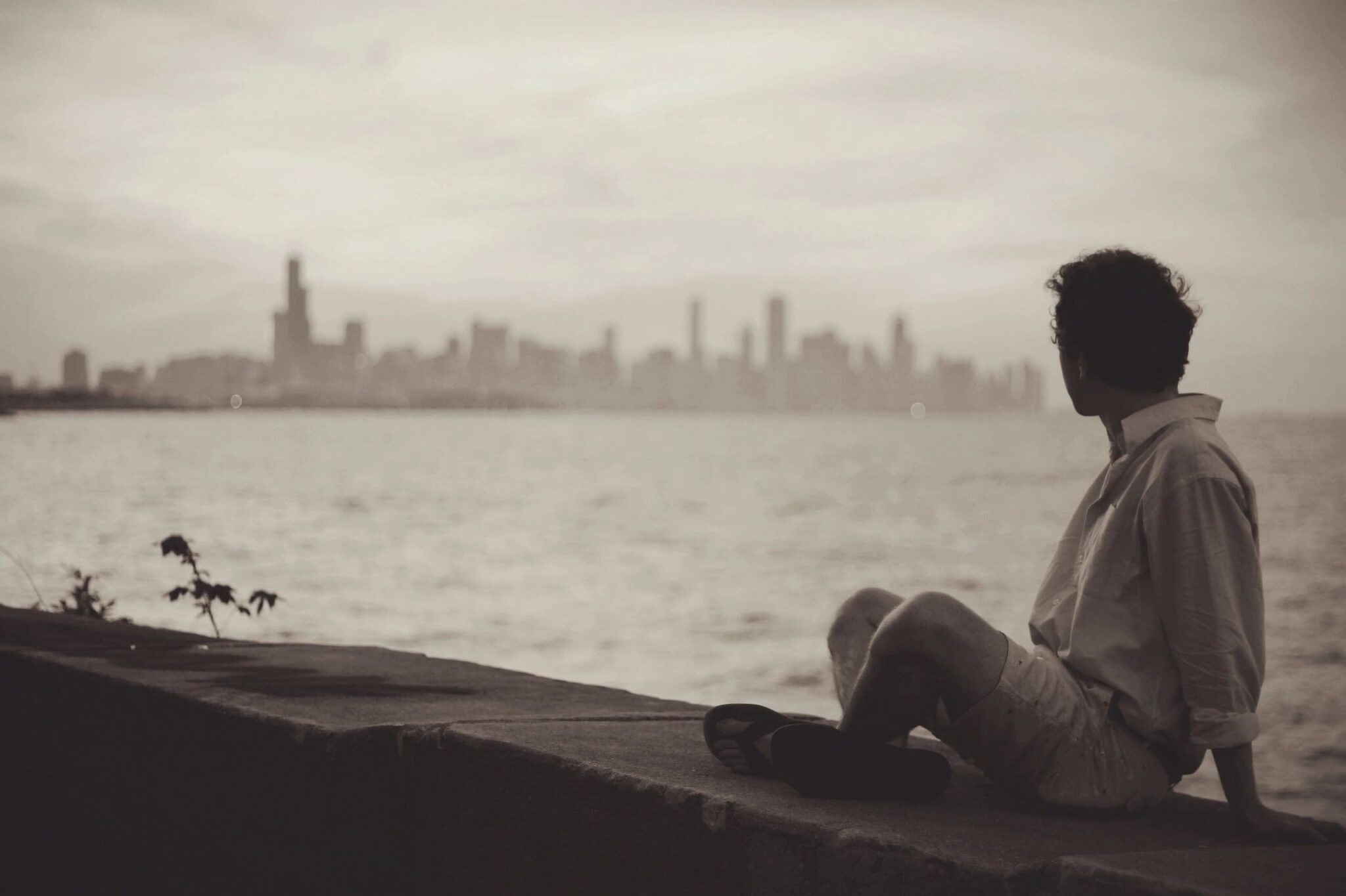 Man looks out across waterfront at a foggy cityscape, evoking idea of brain fog