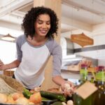 Woman smiling as she chooses fresh produce