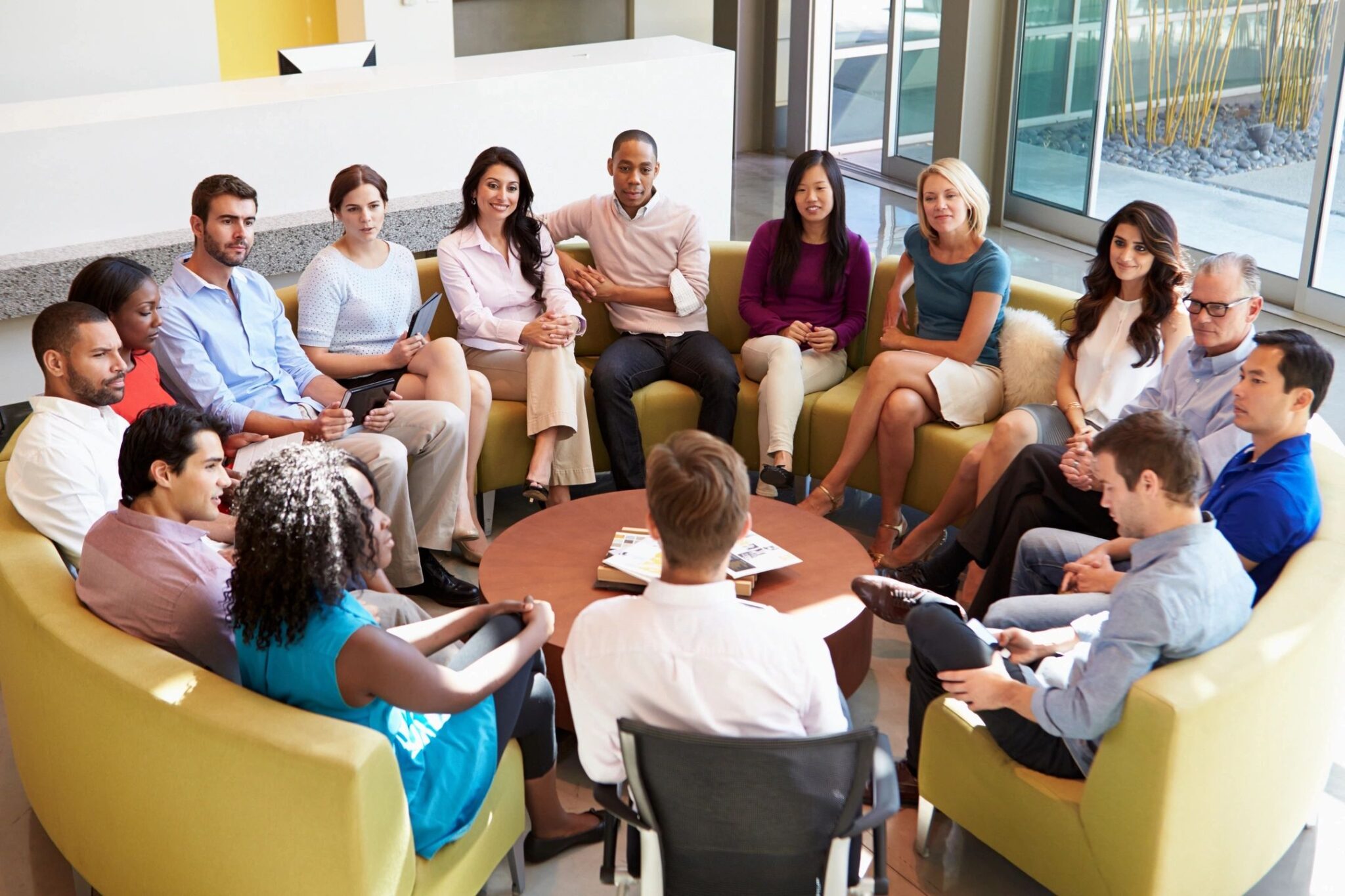 circle of seated people of different races and genders to illustrate how a genetic mutation opened up human language evolution