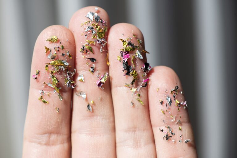 microplastics stuck like sprinkles on a person's fingertips