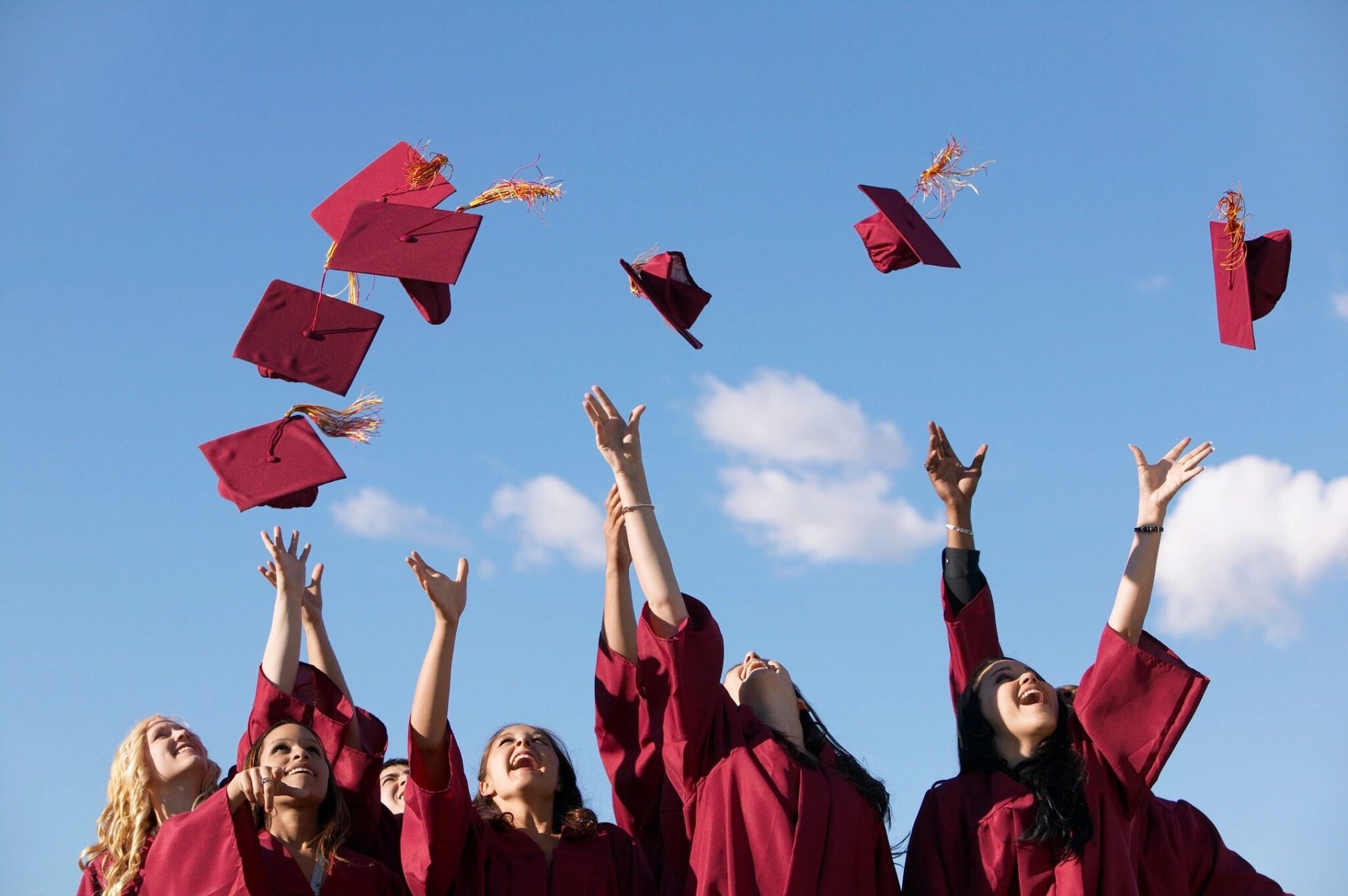 brain wiring as we age, as illustrated by group of children in graduation gowns and graduation caps thrown in the air